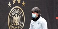 Bundestrainer Löw mit Maske vor einem DFB-Banner