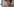 Eine junge Frau mit schwarzen Haaren und Brille blickt in die Kamera. Sie trägt Kopfhörer