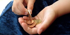 Kinderhände mit Geldmünzen