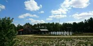 Weiße Messgeräte neben einer Hütte am Waldrand