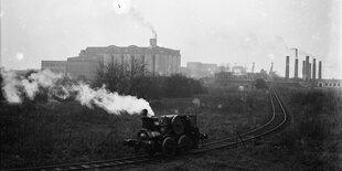 Eine Industrielandschaft, im Vordergrund ist eine Dampflok