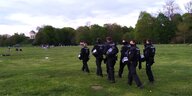 Eine Polizeigruppe auf Patrouille auf einer Wiede im Englischen Garten