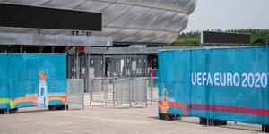 Bauzäune vor der Arena in München, an denen das Logo der EM auf einem Banner hängt