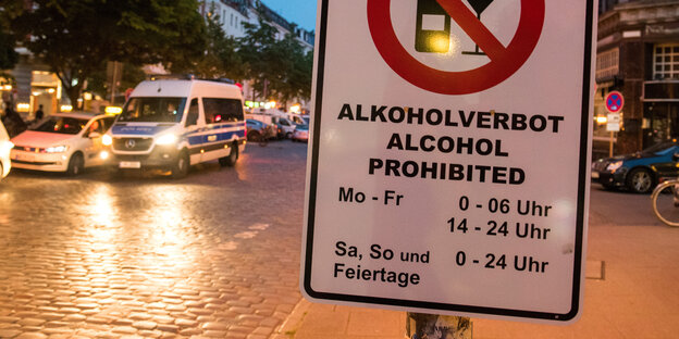 Auf einem Schild steht "Alkoholverbot" mit einem Stundenplan