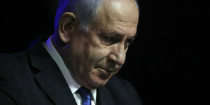 Netanjahu in Nahaufnahme vor dunklem Hintergrund