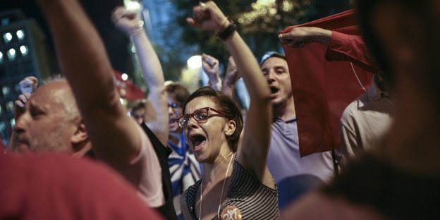 Demonstranten in Athen heben Fäuste in die Luft.