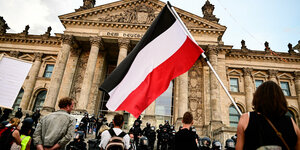 schwarz-weiß-rote Reichsflagge geschwenkt vor dem Reichstag