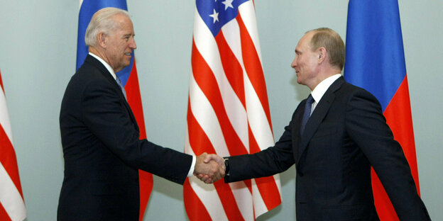 Joe Biden und Wladimir Putin schütteln sich die Hand, aber haben beiden den Arm weit ausgestreckt. Sie sind alte Männer mit wenig Haar.