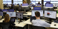Facebook mitarbeiter sitzen in den Büros der Zentrale in Dublin an ihren Rechnern