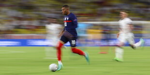 Kylian Mbappé rast mit dem Ball am Fuß