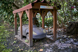 Ein kleines graues verwittertes Spielzeugauto unter einem Mini-Carport aus Holz Ein kleines graues verwittertes Spielzeugauto unter einem Mini-Carport aus Holz