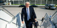 Bundespräsident Frank-Walter Steinmeier steigt mit Aktenkoffer die Treppe zum Flugzeug hinauf