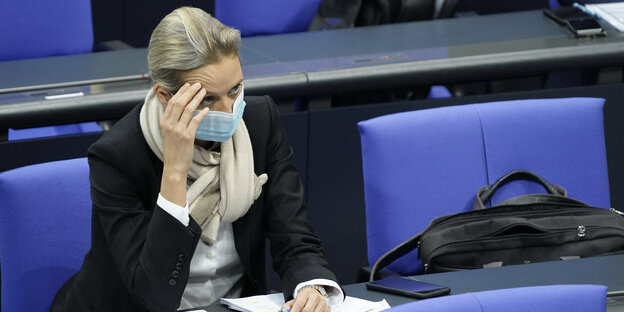 Alice Weidel im Bundestag mit Gesichtsmaske hält sich die Hand an die Stirn