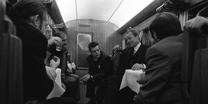 Willy Brandt umgeben von Journalisten in einem Zugabteil