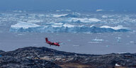 Ein Flugzeug vor Eisbergen im Anflug auf Ilulissat in Grönland