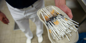 : Ein Arzt hält ein Tablett mit Spritzen, aufgezogen mit mpstoff