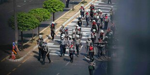 Polizei und Militär ziehen durch die Straße in der Stadt Yangon in Mayanmar