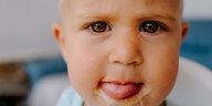 Ein Kleinkind mit eisverschmiertem Mund schaut in die Kamera