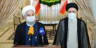 Der scheidende iranische Präsident Hassan Rouhani spricht neben dem gewählten iranischen Präsidenten Ebrahim Rais