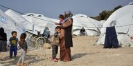 Frau steht mit Baby auf dem Arm im Flüchtlingslager Kara Tepe auf Lesbos