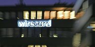 Wirecard-Gebäude nachts mit beleuchteten Fenstern und Wirecard-Schriftzug