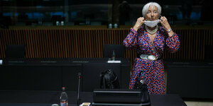 EZB-Präsidentin Christine Lagarde rückt bei einem Treffen mit EU-Finanzministerin ihren Mund-nasen-Schutz zurecht