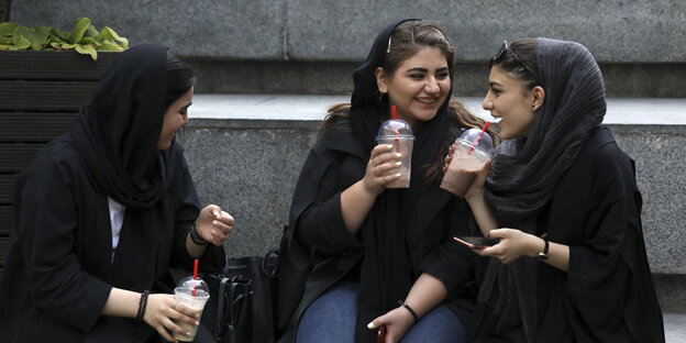 Frauen sitzen auf einer Treppe im Iran