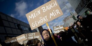 Eine Demonstrantin hält ein Schild mit der Aufschrift "Mein Bauch gehört mir".