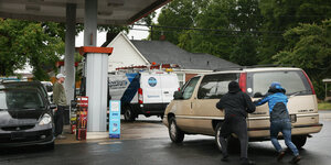 Kund:innen schieben ihre Auto zu einer Tankstelle in North Carolina