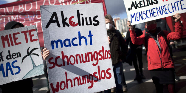 Mieter*innen halten bei einer Demo Plakate hoch. Auf einem steht: "Akelius macht schonungslos wohnungslos"
