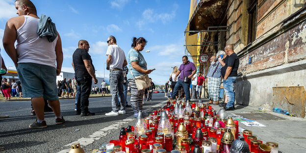 Menschen zünden am Dienstag, 22. Juni, im tschechischen Teplice Kerzen an der Stelle an, an der am Samstag ein Roma-Mann in einem Krankenwagen nach einer Polizeiaktion starb.