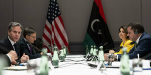 US-Außenminister Blinken am Tisch mit dem libyschen Regierungschef Dbeibeh vor den beiden Flaggen
