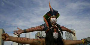 Indigene Fraune tragen Masken mit einer Aufschrift gegen Salles