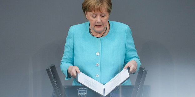 undeskanzlerin Angela Merkel (CDU) klappt nach der Regierungserklärung zum bevorstehenden EU-Gipfel bei der Sitzung des Deutschen Bundestags das Redemanuskript zu