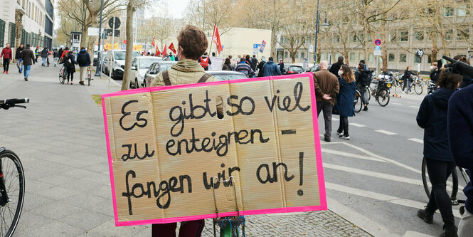 Ein Demonstrant trägt ein Enteignungsplakat auf dem Rücken