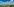 Panoramablick von einem Hügel aus über eine gegend mit Bäumen und Feldern, auf denen Windräder stehen.