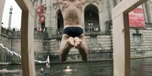 Einer Schwimmern springt vor dem Start des Berliner Flussbad Pokals 2015 am Bode-Museum in Berlin in die Spree