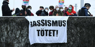 Demonstranten zeigen ein Banner mit der Aufschrift: Rassismus tötet