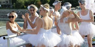 Tänzer und Tänzerinnen stehen auf einem Wagen der Pride Parade