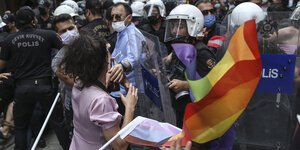 Demonstranten mit Regenbogenfahne werden von der Polizei festgehalten