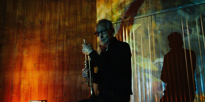 Der Trompeter Jon Hassell mit seinem Instrument, bunt angeleuchtet.