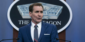 Ein Mann in blauem Anzug steht an einem Redepult vor dem Logo des Pentagon