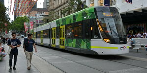 Straßenbahn fährt durch Einkaufsstraße in Melbourne