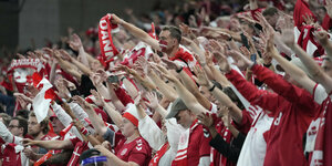 Dänische Fans im Stadion heben dicht an dicht gedrängt die Arme