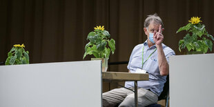 Hubert Ulrich in der Saarlandhalle in Saarbruecken auf ihrem Landesparteitag sitzt neben Sonnenbllumen