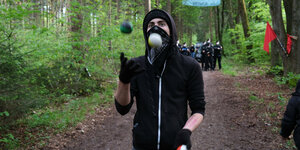 Vermummter Aktivist jongliert im Forst Kasten mit zwei Bällen