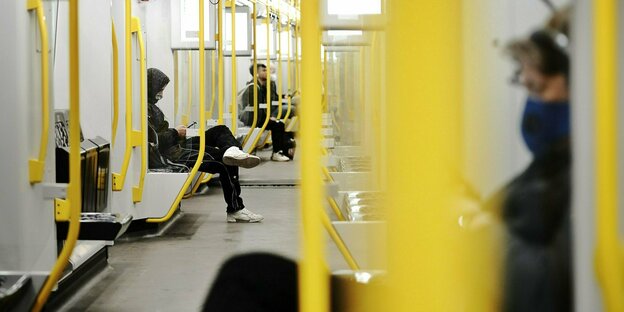 Wenige Fahrgäste mit Mund-Nasenschutz sitzen am Morgen in der U-Bahn