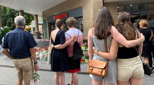 Mensche legen Blumen in Würzburg nieder