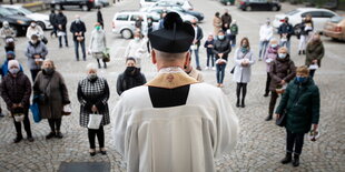 Priester vor einer kleinen gruppe von Gläubigen