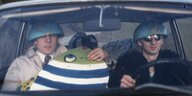 Das Duo Fische mit halben Globen auf dem Kopf in einem Auto